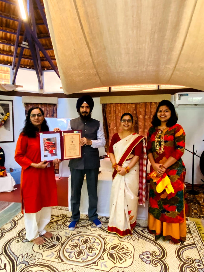 Group receiving an award certificate at a cultural event
